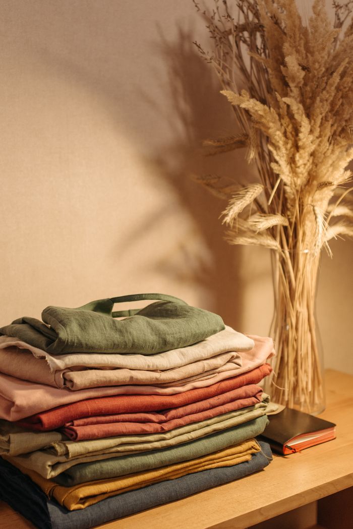 Aesthetic arrangement of linen clothes and dried flowers on a wooden table.